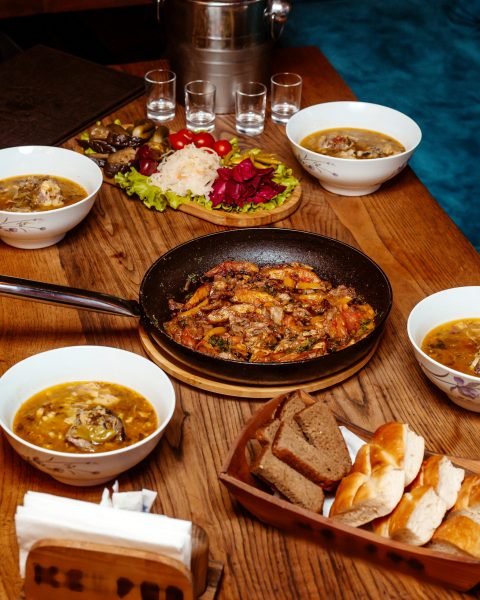 meat with vegetables in pan and pickles